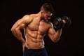 Handsome power athletic man with dumbbell confidently looking forward. Strong bodybuilder with six pack, perfect abs Royalty Free Stock Photo