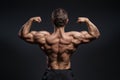 Handsome power bodybuilder showing his back