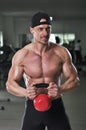 Handsome powerful athletic man doing biceps exercise with kettle bell Royalty Free Stock Photo