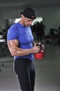 Handsome powerful athletic man doing biceps exercise with kettle bell Royalty Free Stock Photo