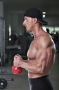 Handsome powerful athletic man doing biceps exercise with kettle bell Royalty Free Stock Photo