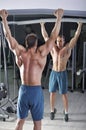 Handsome powerful athletic man doing pull-ups. Strong bodybuilder with perfect abs, back and chest. Royalty Free Stock Photo