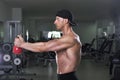 Handsome powerful athletic man doing shoulder exercise with kettle bell