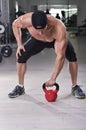 Handsome powerful athletic man performing kettle bell exercise. Royalty Free Stock Photo