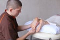 Handsome practicing masseur kneads feet of female client, who li