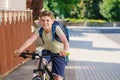 Handsome preteen boy going to school on bike. Teenager ride bicycle. Safe way to high school. Happy child boy with