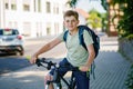 Handsome preteen boy going to school on bike. Teenager ride bicycle. Safe way to high school. Happy child boy with