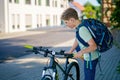 Handsome preteen boy going to school on bike. Teenager ride bicycle. Safe way to high school. Happy child boy with