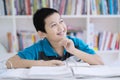 Handsome preteen looks pensive in the library