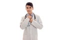 Handsome pretty brunette male doctor in uniform with stethoscope on his neck posing on camera isolated on white Royalty Free Stock Photo