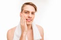 Handsome pretty young man with towel touching his face after shave Royalty Free Stock Photo