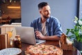 Handsome programmer with pizza and laptop