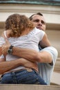 Handsome proud man hugging woman close on balcony