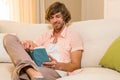 Handsome reading a book sitting on the couch