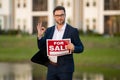 Handsome real estate agent holding banner house for sale. House with land and insurance. Business man real estate agent Royalty Free Stock Photo