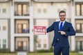 Handsome real estate agent holding banner house for sale. House with land and insurance. Man real estate agent in Royalty Free Stock Photo