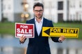 Handsome real estate agent holding banner house for sale. House with land and insurance. Business man real estate agent Royalty Free Stock Photo