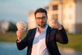 Handsome real estate agent holding money dollars and house keys. Man real estate agent in business suit presenting the Royalty Free Stock Photo