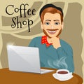 Handsome red haired hipster man with laptop enjoying a hot coffee in coffee shop