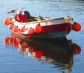 A handsome wooden boat with two seagulls reflected in the sea at Mevagissey harbour Cornwall England Royalty Free Stock Photo