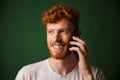 Handsome redhead bearded man talking on phone