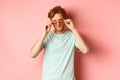Handsome redhead man in summer sunglasses looking sassy at camera, standing over pink background Royalty Free Stock Photo