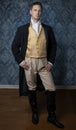 A handsome Regency gentleman wearing a gold waistcoat, breeches, and a black coat Royalty Free Stock Photo