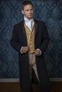 A handsome Regency gentleman wearing a gold waistcoat, breeches, and a black coat Royalty Free Stock Photo