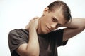 Handsome relaxed man in t-shirt. Portrait of young seductive guy, looking at camera with hands behind his head, gray Royalty Free Stock Photo