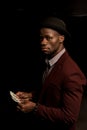 handsome rich african american man in hat holding dollar banknotes,