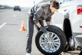Worker changing car wheel on the highway Royalty Free Stock Photo