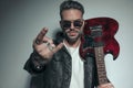 Handsome rock artist saluting with the rock on sign