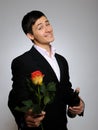 Handsome romantic young man with rose flower