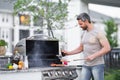 Handsome 40s man preparing barbecue. Male cook cooking meat on barbecue grill. Guy cooking meat on barbecue for summer Royalty Free Stock Photo