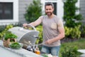 Handsome 40s man preparing barbecue. Male cook cooking meat on barbecue grill. Guy cooking meat on barbecue for summer Royalty Free Stock Photo