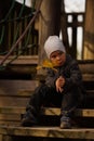 A handsome sad little boy sitting on the step of the old stairs and thinking about something Royalty Free Stock Photo