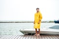 Handsome sailor in yellow cloak standing at the pier