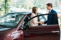 Handsome sales Manager shaking hands to customer after selling a car Royalty Free Stock Photo