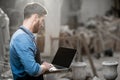 Sculptor with laptop in the studio Royalty Free Stock Photo