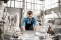 Sculptor working with laptop in the studio Royalty Free Stock Photo