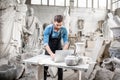 Sculptor working with laptop in the studio Royalty Free Stock Photo