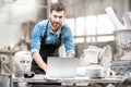 Sculptor working with laptop in the studio Royalty Free Stock Photo