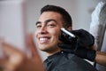 Handsome self confident male with beautiful smile getting hairdressing in beauty salon Royalty Free Stock Photo