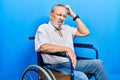 Handsome senior man with beard sitting on wheelchair confuse and wondering about question Royalty Free Stock Photo