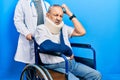 Handsome senior man with beard sitting on wheelchair with neck collar confuse and wondering about question Royalty Free Stock Photo