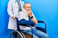 Handsome senior man with beard sitting on wheelchair with neck collar laughing and embarrassed giggle covering mouth with hands, Royalty Free Stock Photo