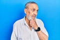 Handsome senior man with beard wearing casual white shirt with hand on chin thinking about question, pensive expression Royalty Free Stock Photo