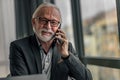 Handsome senior man businessman entrepreneur making a phone call looking at camera Royalty Free Stock Photo