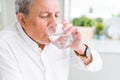Handsome senior man drinking a fresh glass of water at home Royalty Free Stock Photo