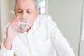 Handsome senior man drinking a fresh glass of water at home Royalty Free Stock Photo